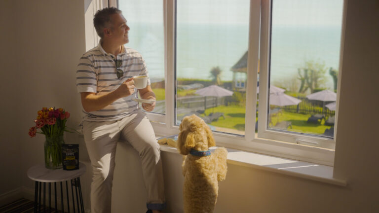 A guest and their dog enjoying the sea view from their room