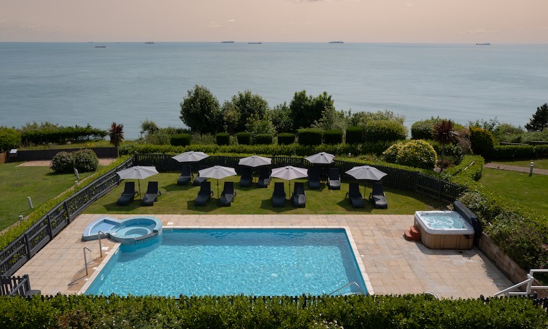 The outdoor pool and gardens at Luccombe Manor looking out to sea