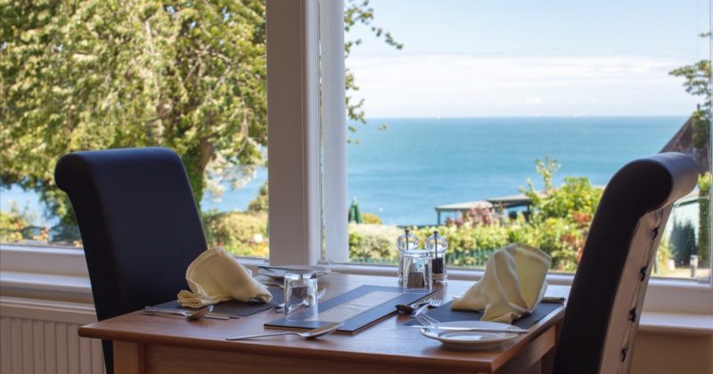 A table laid by the window with a view of the sea