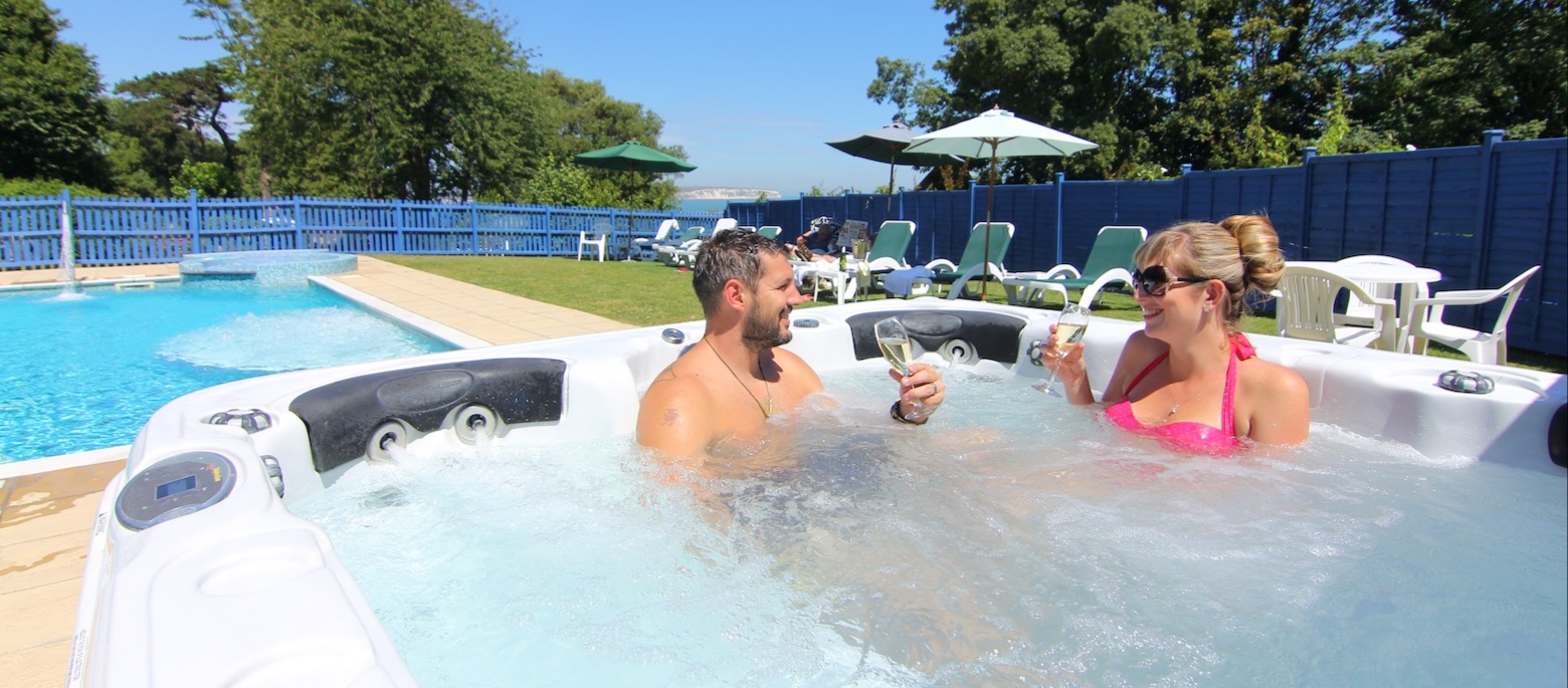 Guests relaxing in the outdoor hot tub at Luccombe Manor